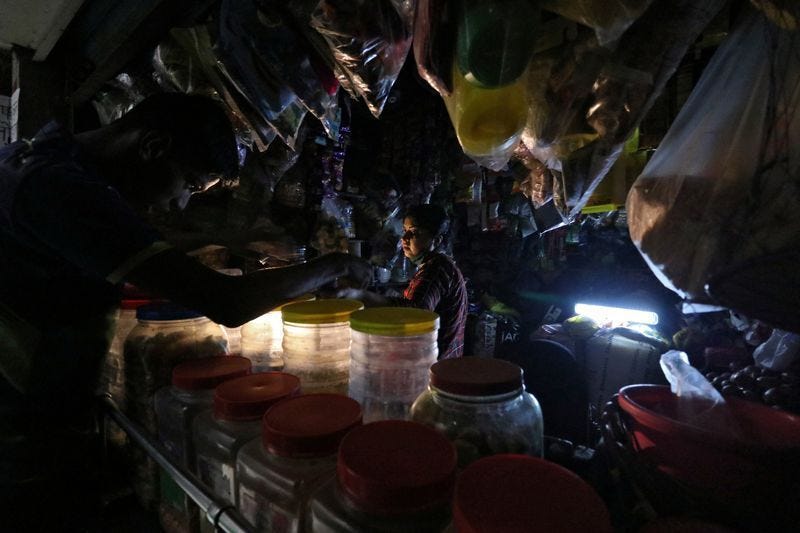 A woman works in a dark kitchen. A woman works in a dark kitchen.