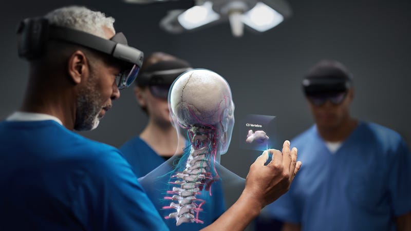 Three medical professionals all wearing HoloLens looking at a rendering of a human skeleton.
