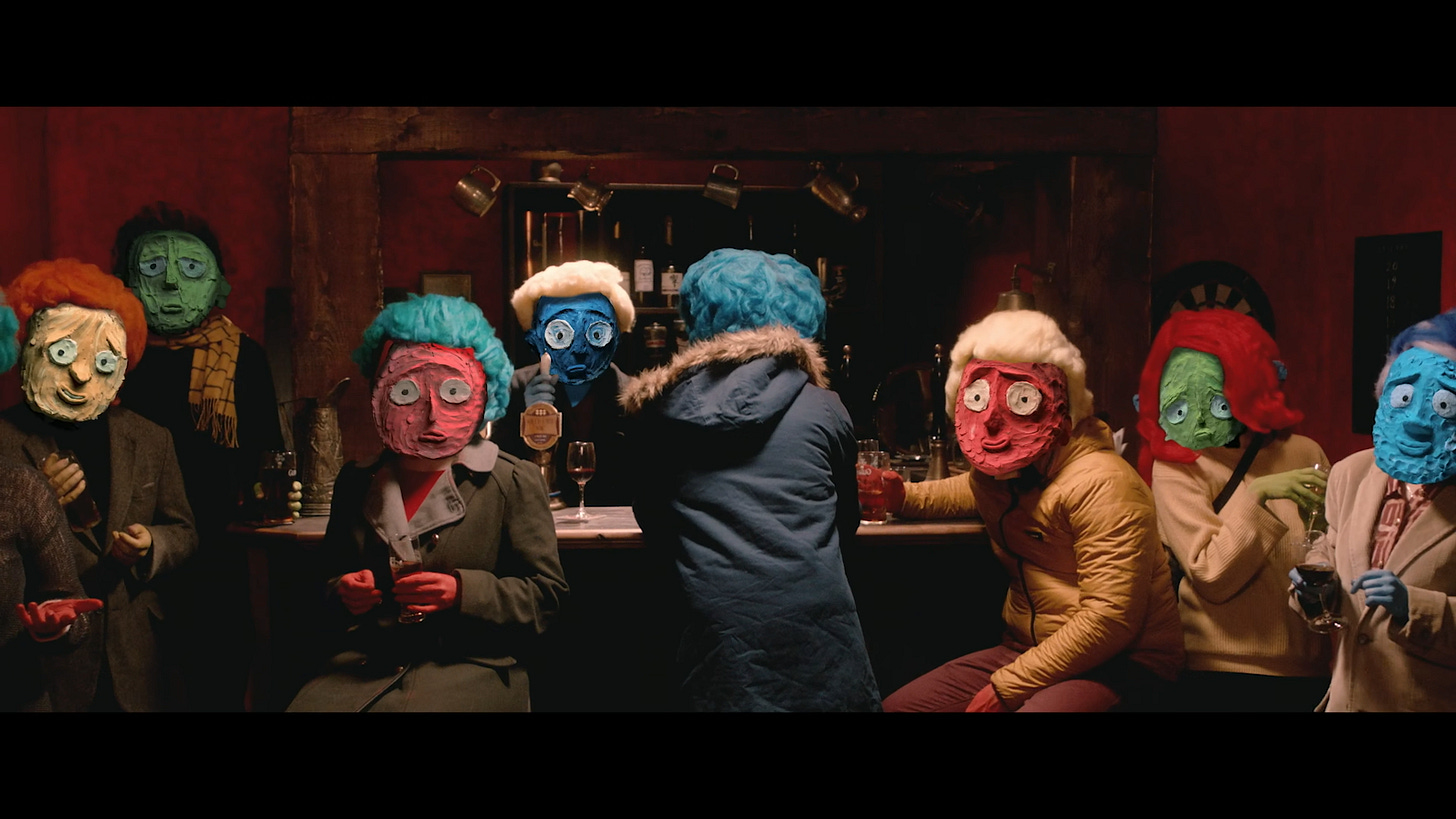 Still from the short film: A group of people with claymation faces sit at a bar staring down the camera at the viewer.