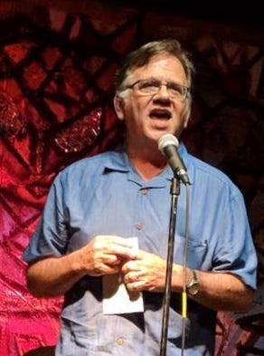 poet Chuck Joy speaking at a microphone.