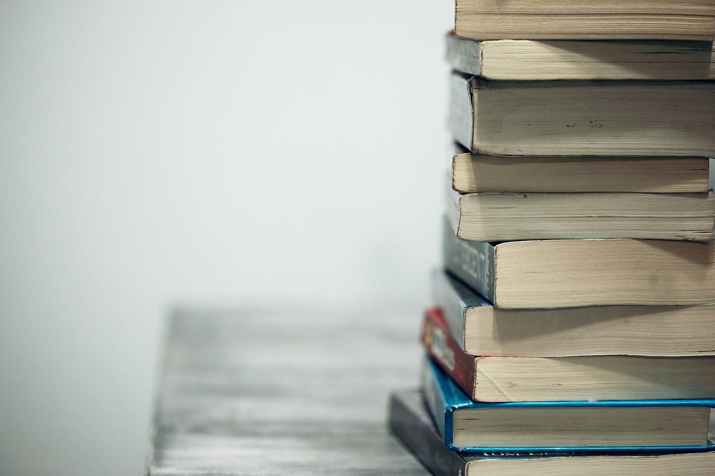 Photo of a stack of books on a table. Photo of a stack of books on a table.