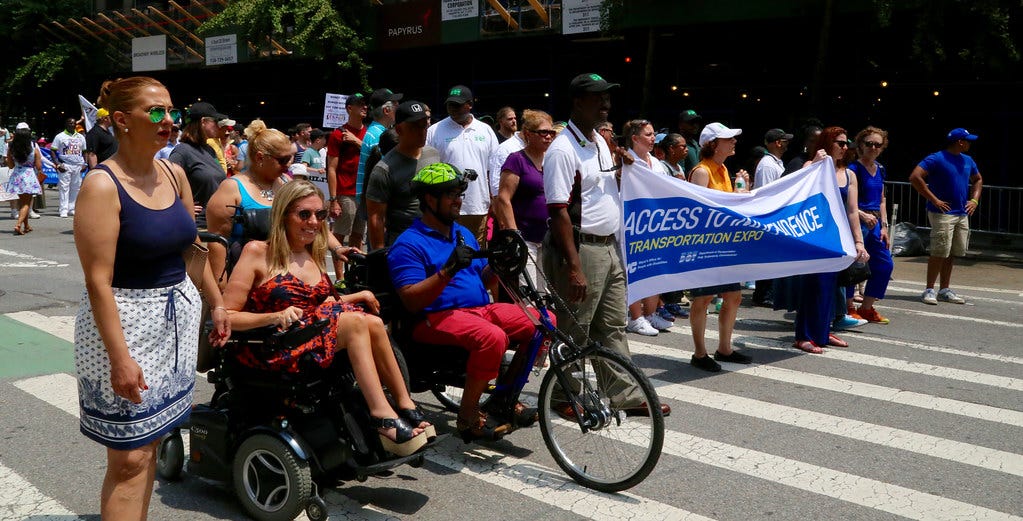 A variety of disabled people smile for a picture. A variety of disabled people smile for a picture.