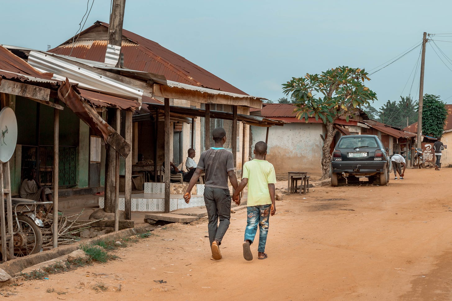 2 men walking hand in hand in Ediba A photo by David Elikwu