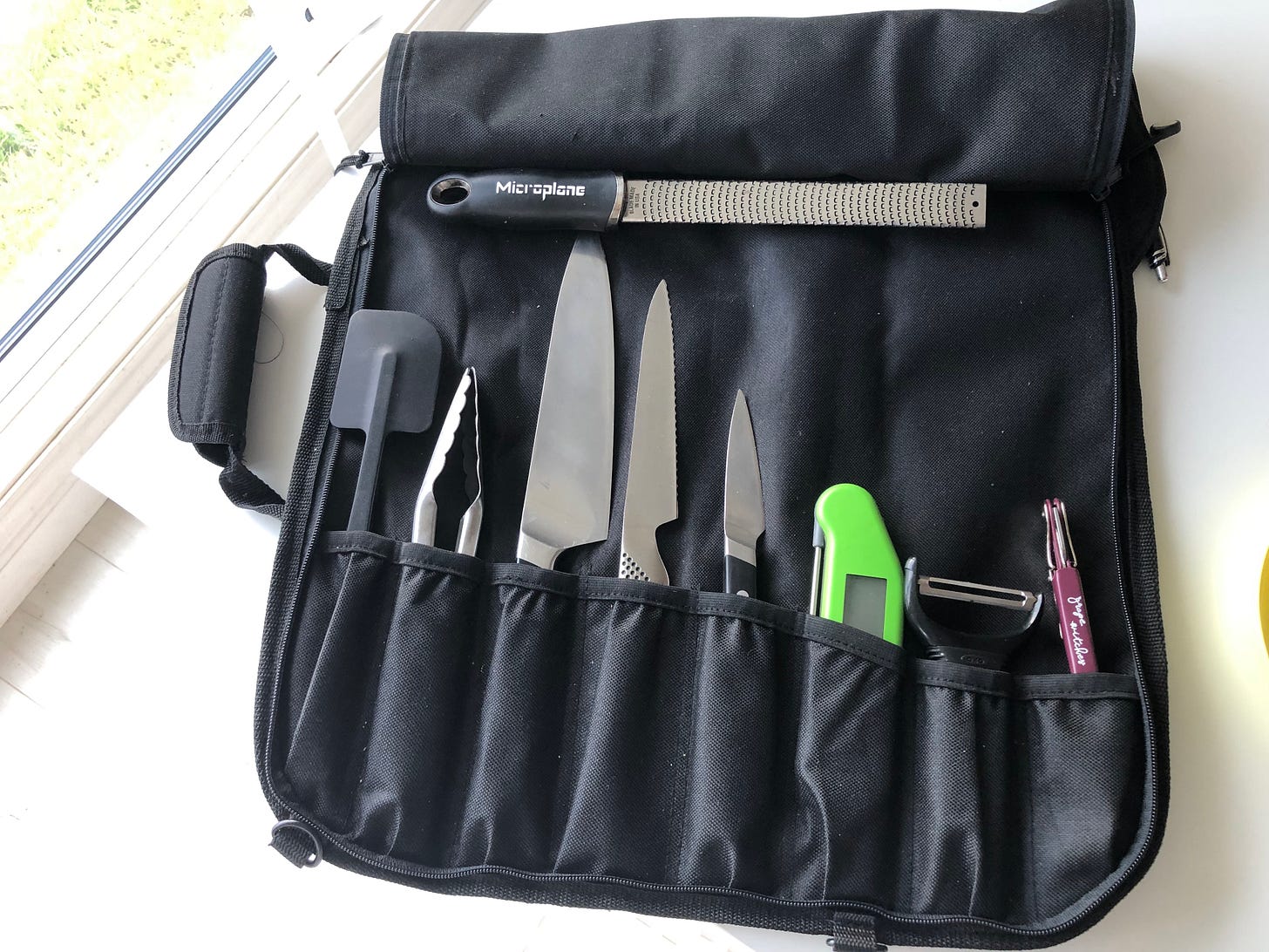 A nylon knife roll containing essential kitchen equipment A nylon knife roll containing essential kitchen equipment