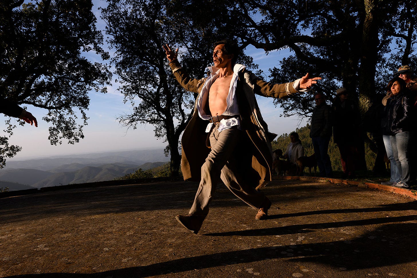 Dancer in spectacular Portuguese mountain setting watched by audience members. Dancer in spectacular Portuguese mountain setting watched by audience members.