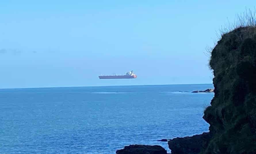 A tanker appears to hover high above the surface of the sea off the Cornish coast.