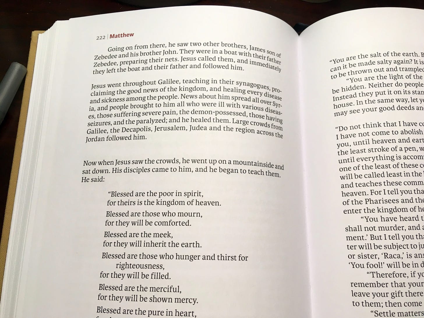 A reader's Bible open to the "Beatitudes" in Matthew's Gospel: "Blessed are the poor in spirit..."
