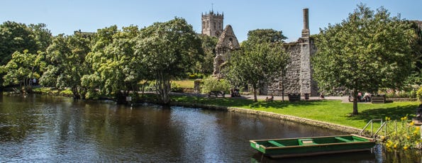 River next to castle ruins with a church in the background. River next to castle ruins with a church in the background.