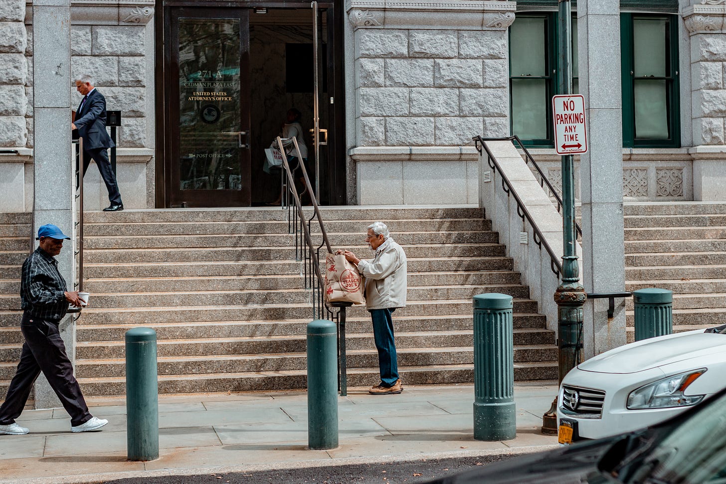 An old man with grocery bag standing and resting on stairs in New York: A photo by David Elikwu