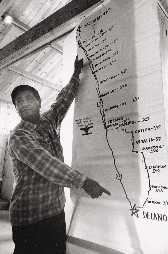 Cesar Chavez stands in front of a map of 1966 march route.