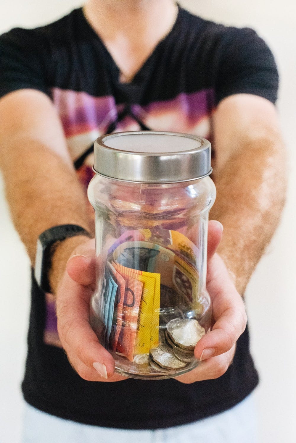 man holding clear glass jar