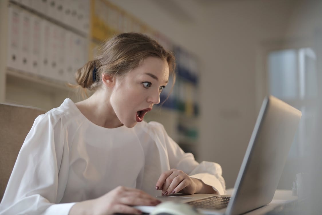 Woman in White Long Sleeve Shirt Using Silver Laptop Computer Woman in White Long Sleeve Shirt Using Silver Laptop Computer