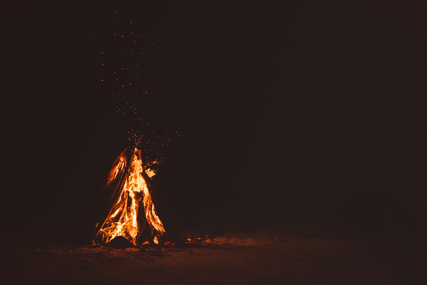 Photo of a small campfire in the dark.