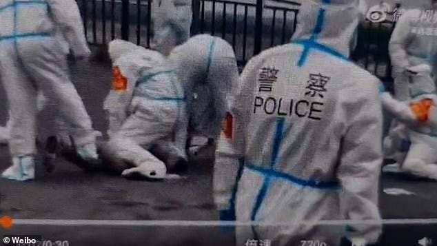 Cops are seen pinning down a man outside his home as they try to create a new isolation hub