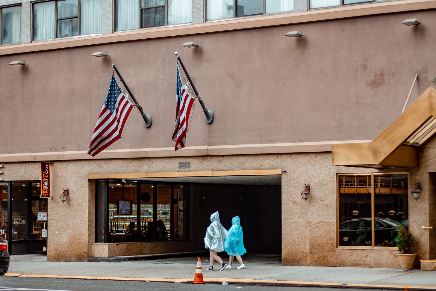 2 girls wearing raincoat as PPE walking on the sidewalk in New York: A photo by David Elikwu 
