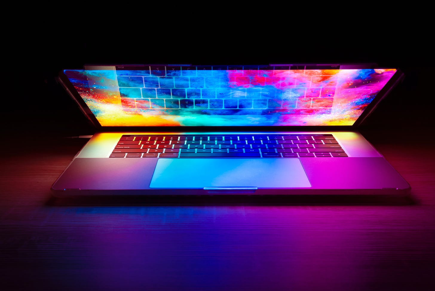 Photo of a half-opened laptop with the screen showing a rainbow-colored explosion. Joshua Woroniecki / Unsplash