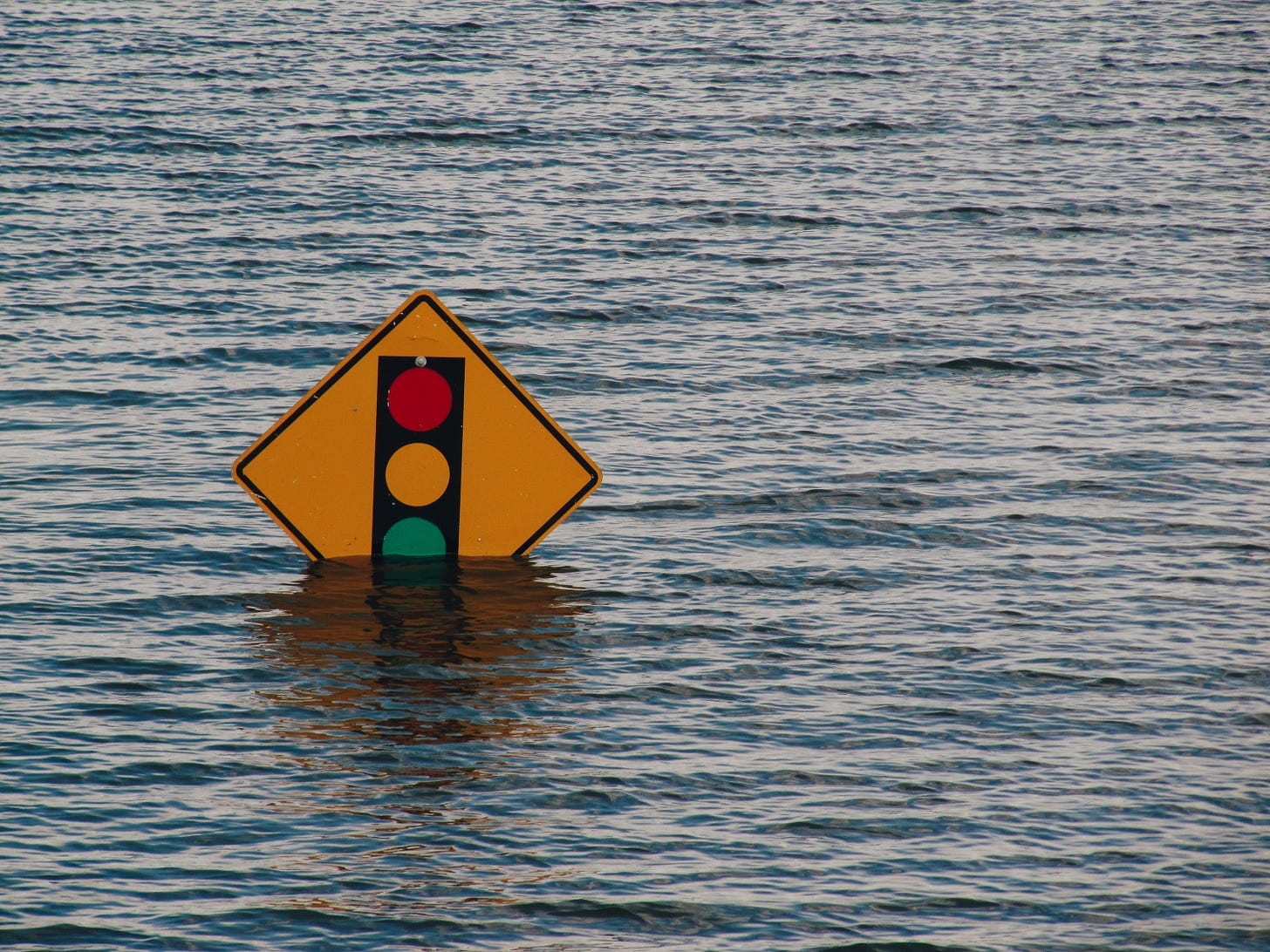 Photo of a traffic sign, partially submerged by floodwaters.