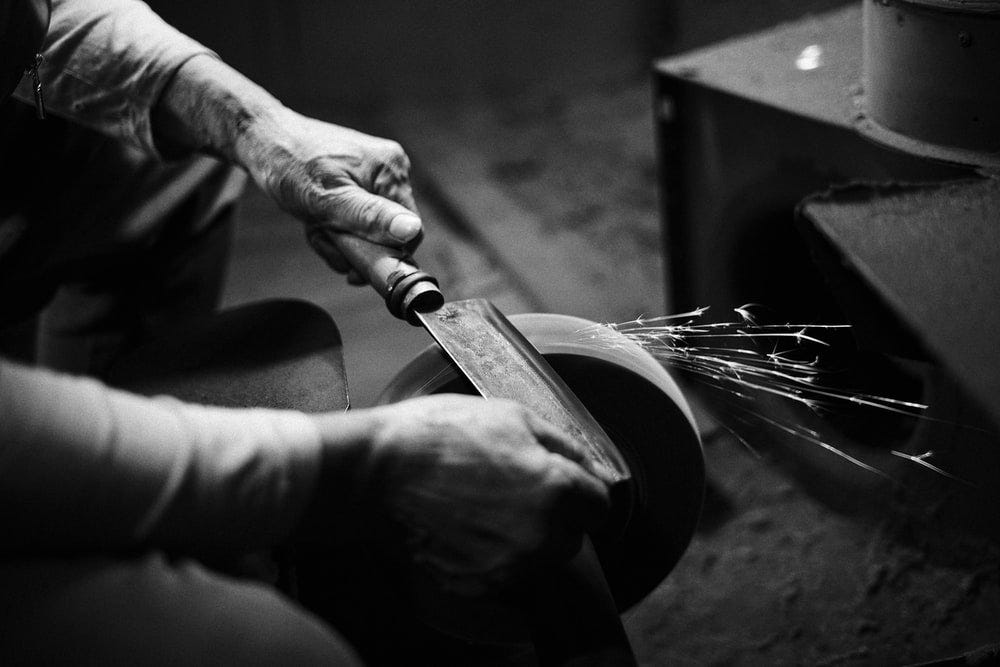 person grinding cleaver person grinding cleaver