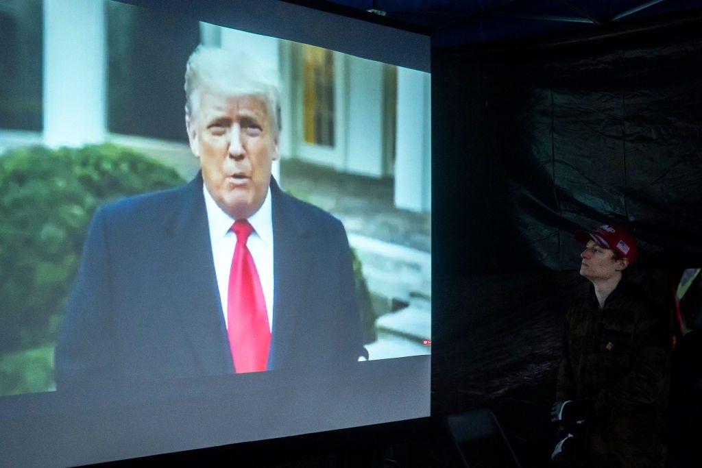 A supporter of President Trump watches a message asking violent protesters to go home on January 6, 2021 in Salem, Oregon. Trump supporters gathered at state capitals across the country to protest today's ratification of Joe Biden's Electoral College victory over President Trump in the 2020 election. (Photo by Nathan Howard/Getty Images)
