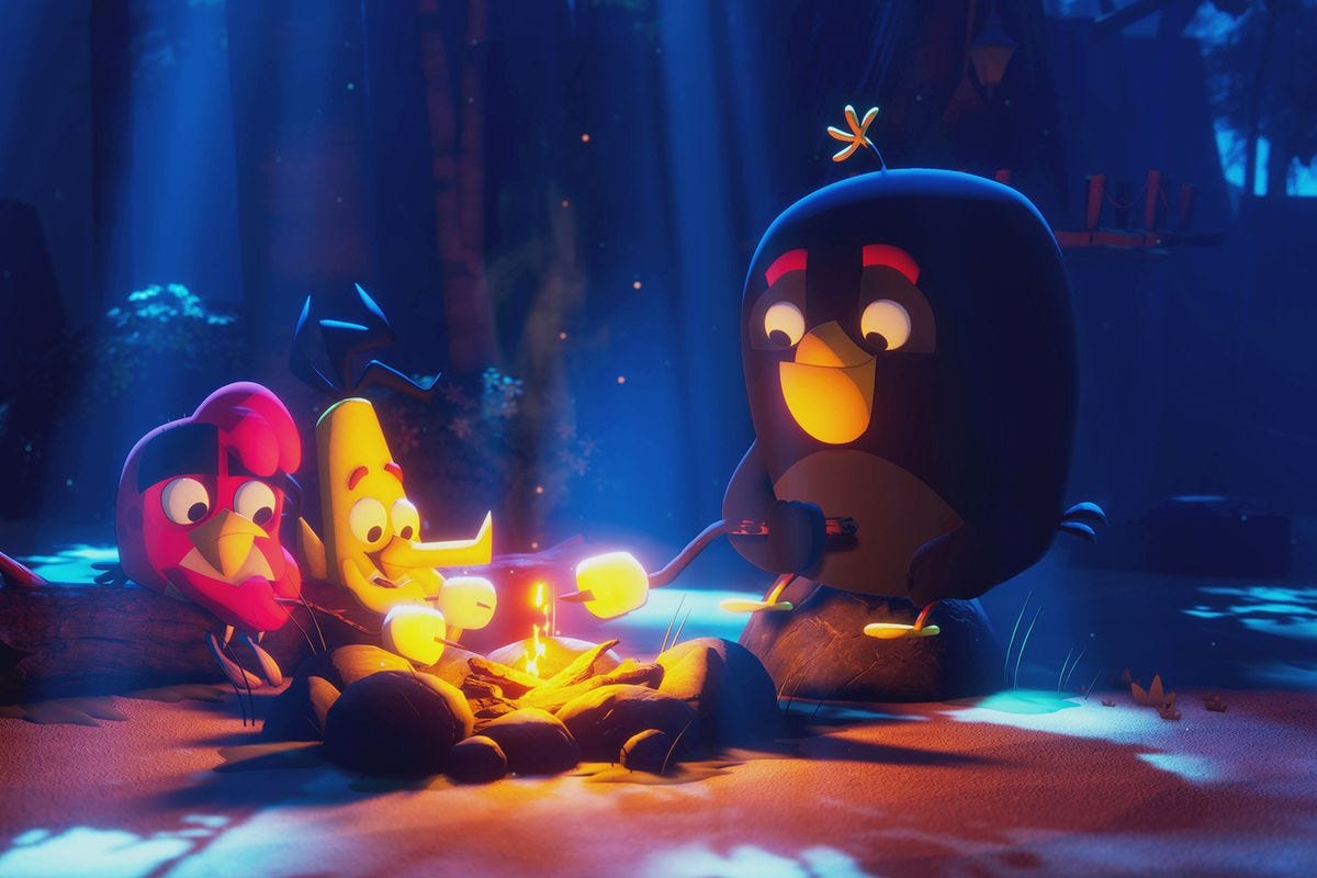 Angry Birds Red, Bomb, and Chuck toast marshmallows around a campfire