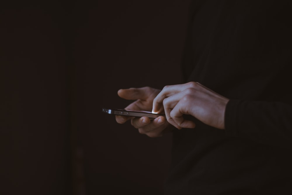 silhouette photo of person holding smartphone silhouette photo of person holding smartphone