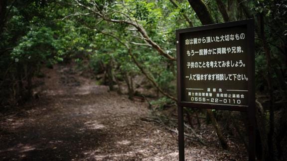 A sign at the entrance of the Aokigahara forest urges suicidal visitors to reach out for help. A sign at the entrance of the Aokigahara forest urges suicidal visitors to reach out for help.