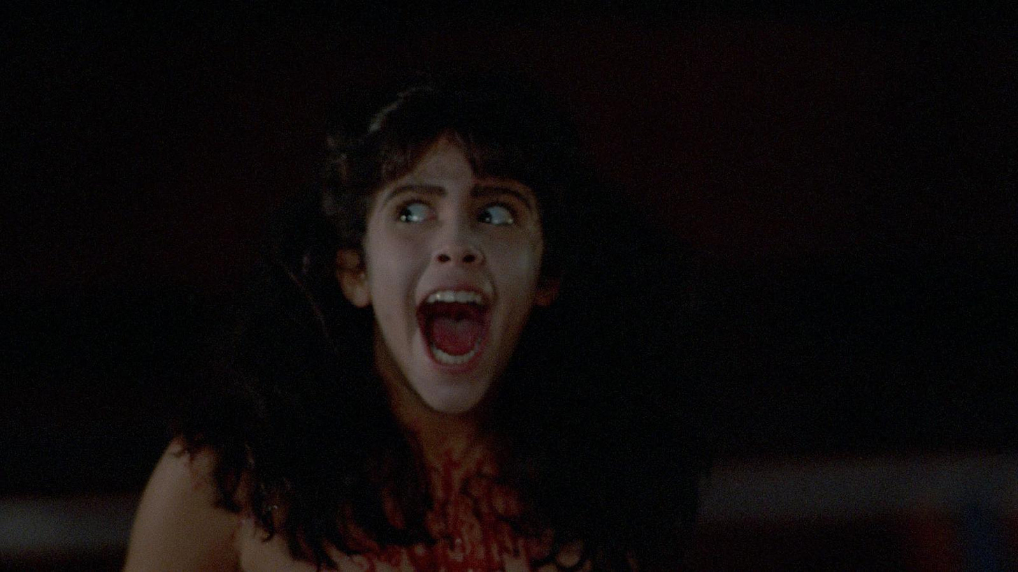Angela in Sleepaway Camp screaming in the dark while covered in blood from neck down