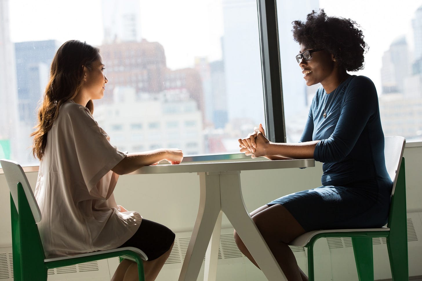 Two women talking at a table. Two women talking at a table.