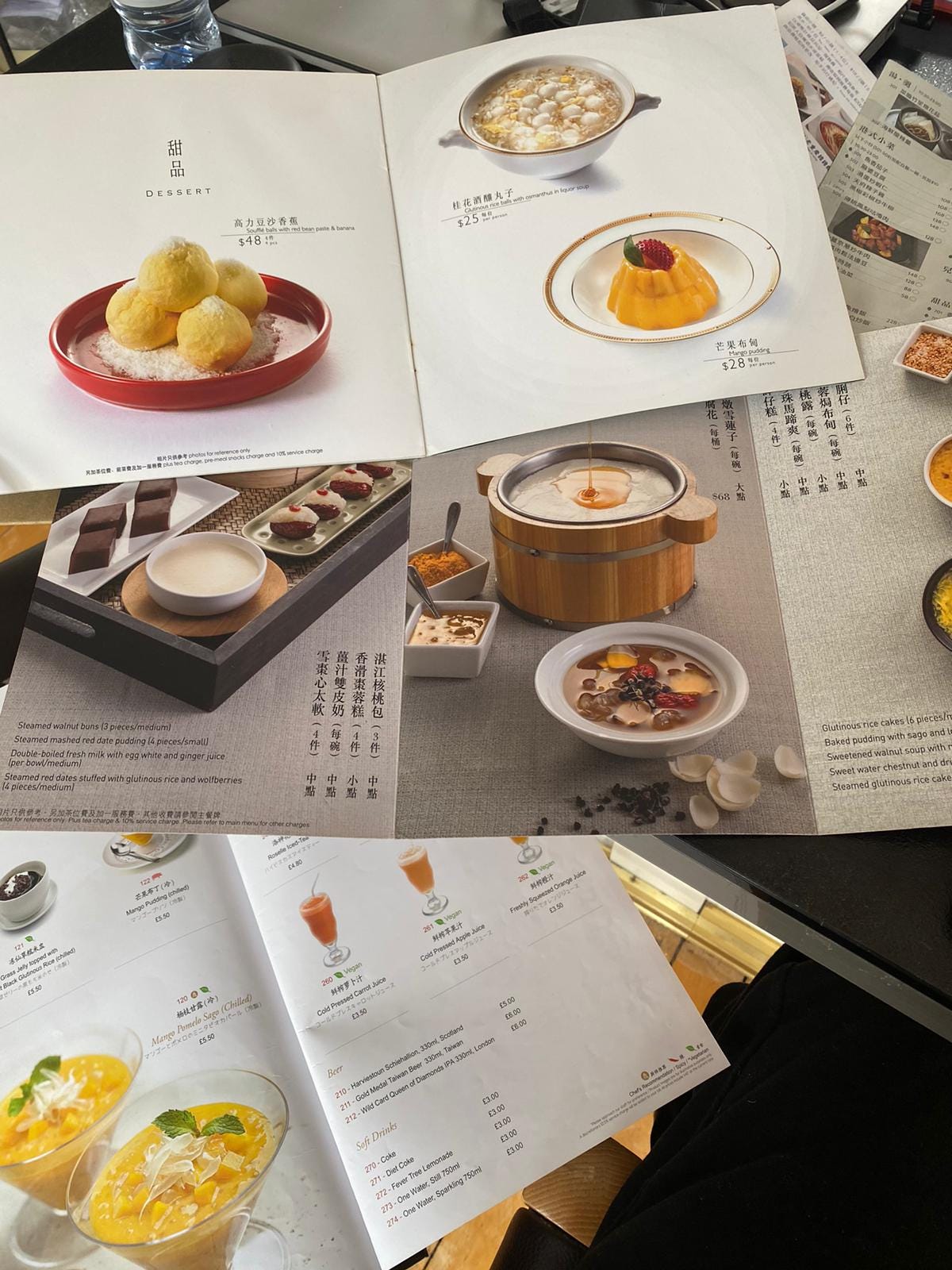 An overhead shot of several Hong Kong restaurant menus open to their dessert pages featuring photos and text An overhead shot of several Hong Kong restaurant menus open to their dessert pages featuring photos and text