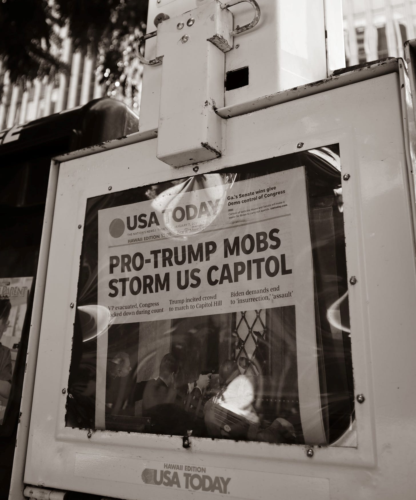 Photo of a newspaper bin with a headline that reads "Pro-Trump Mobs Storm US Capitol."