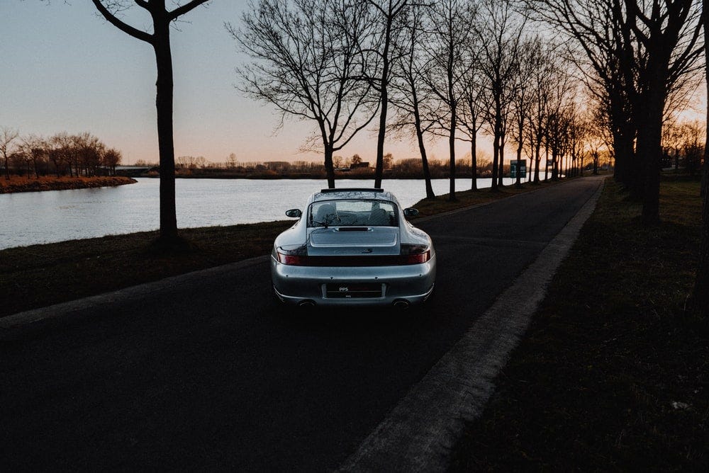 white car parked on sidewalk during sunset white car parked on sidewalk during sunset