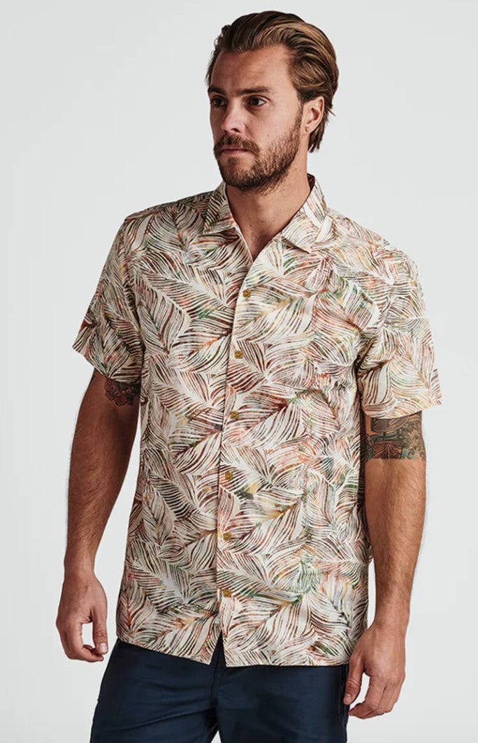 a man wears the roark revival java leaf shirt. it looks good