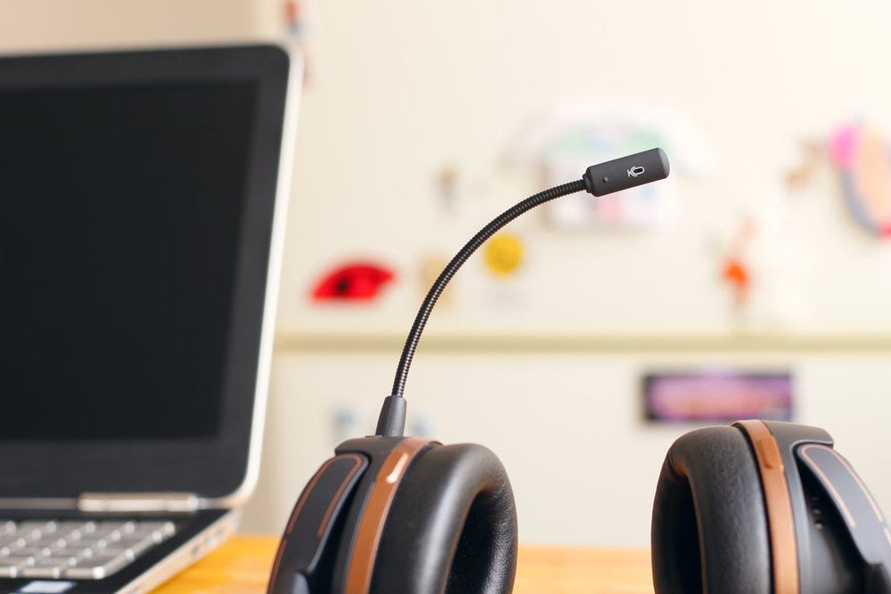 black and brown headset near laptop computer black and brown headset near laptop computer