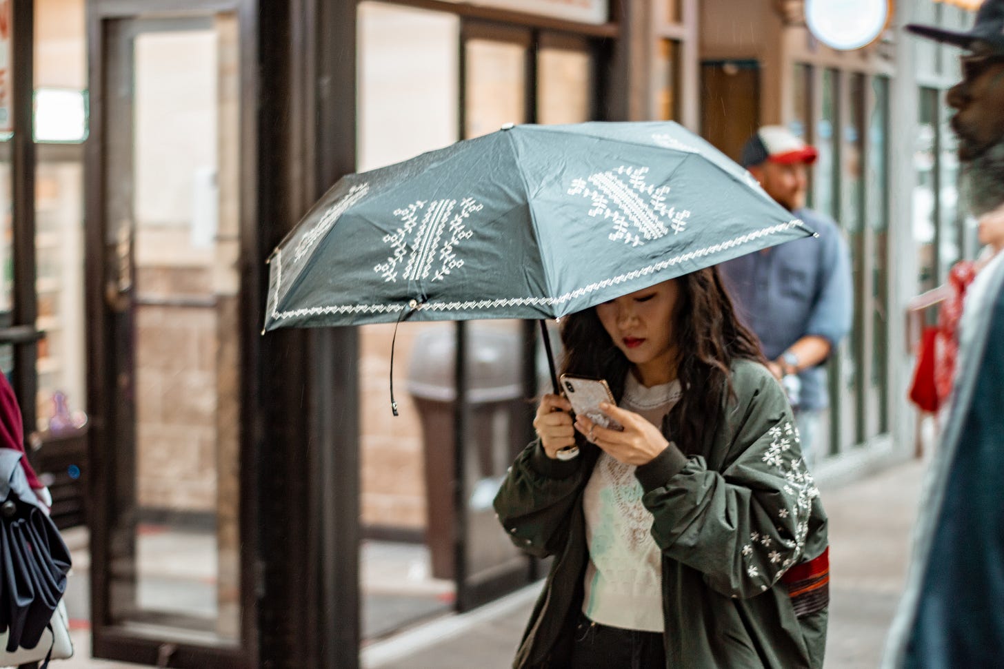 A woman walking while using her phone in New York: A photo by David Elikwu