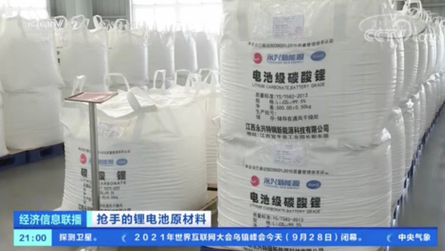 A screenshot of a news segment produced by China's CCTV network. The image shows rows upon rows of sterile-looking white bags containing lithium carbonate sitting on a factory floor A screenshot of a news segment produced by China's CCTV network. The image shows rows upon rows of sterile-looking white bags containing lithium carbonate sitting on a factory floor