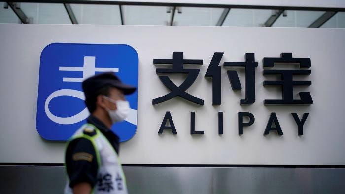 A security guard wearing a mask walks past an Alipay logo at the Shanghai office of Alipay, owned by Ant Group A security guard wearing a mask walks past an Alipay logo at the Shanghai office of Alipay, owned by Ant Group