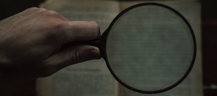 Reading book with magnifying glass Reading book with magnifying glass