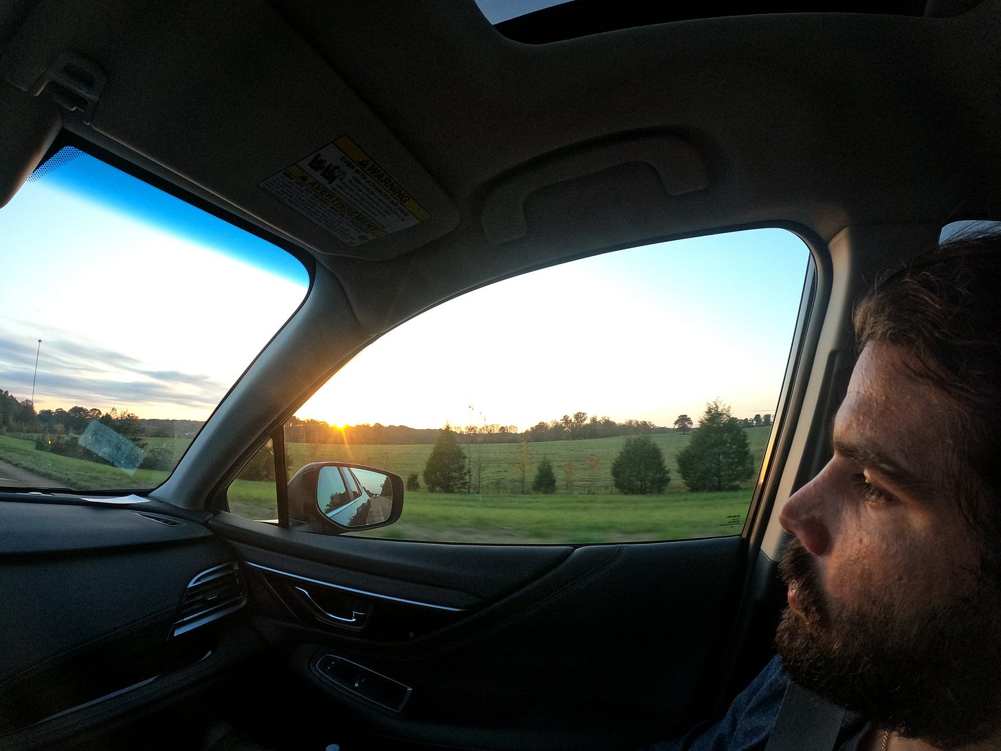 Anthony staring out the window as the sun sets over a green field in the Mississippi Delta Anthony staring out the window as the sun sets over a green field in the Mississippi Delta