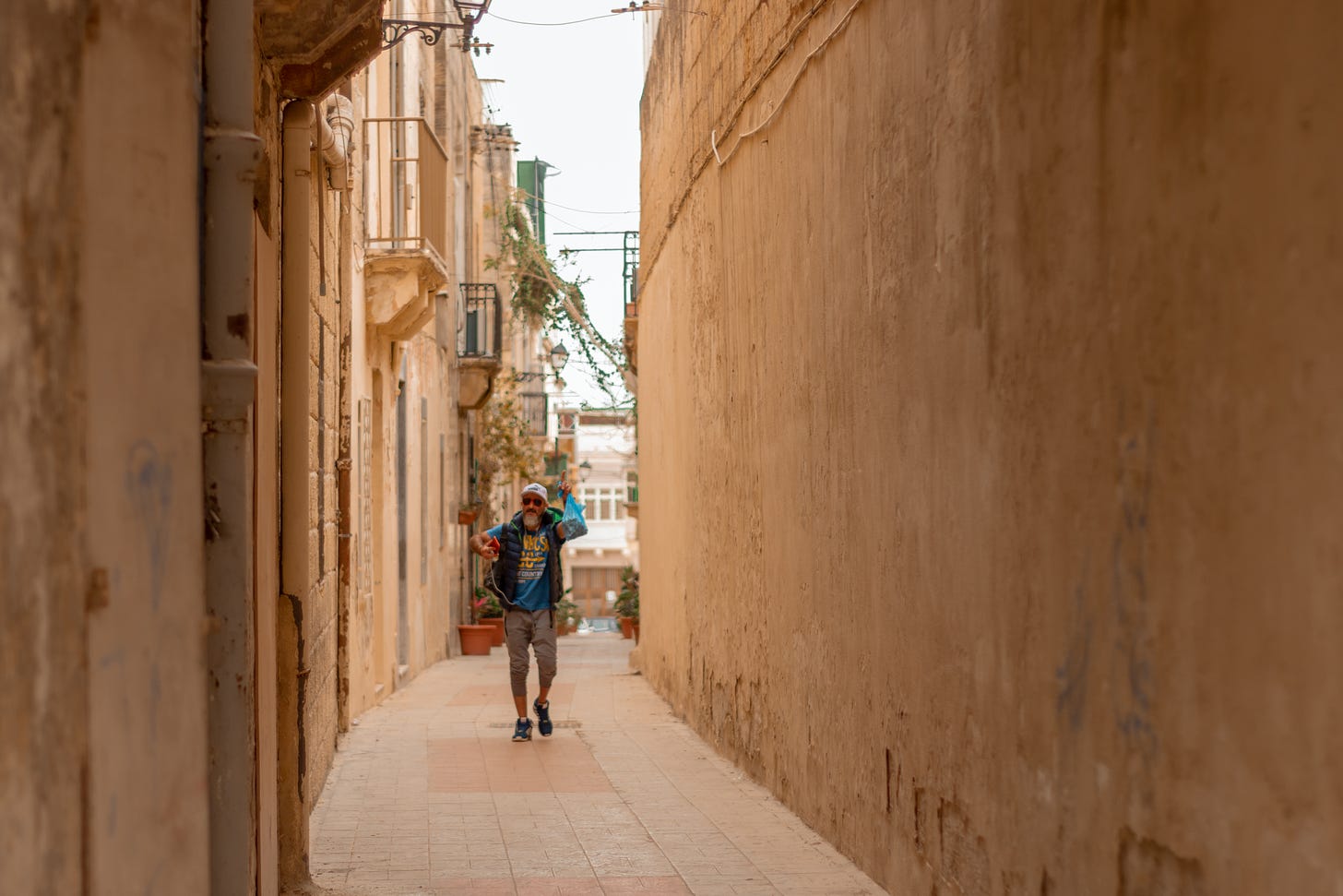 An old man walking in a narrow street in Malta: A photo by David Elikwu