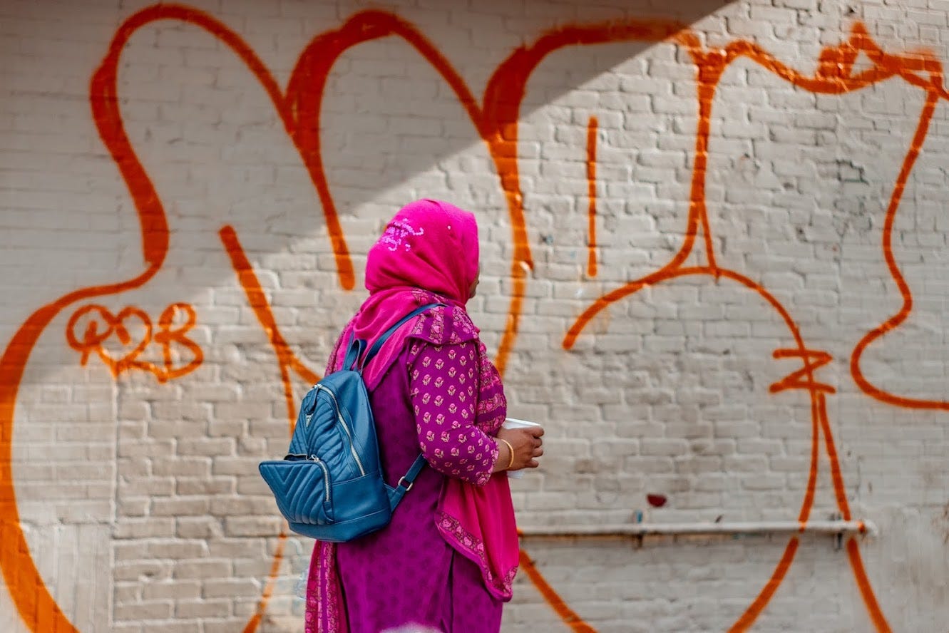  A woman wearing hijab holding a disposable cup while walking in New York: A photo by David Elikwu