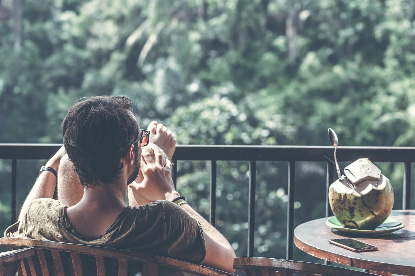 image of a man sitting in a chair on a balcony for article titled “In Support of The Idle Unambitious” by Larry G. Maguire image of a man sitting in a chair on a balcony for article titled “In Support of The Idle Unambitious” by Larry G. Maguire