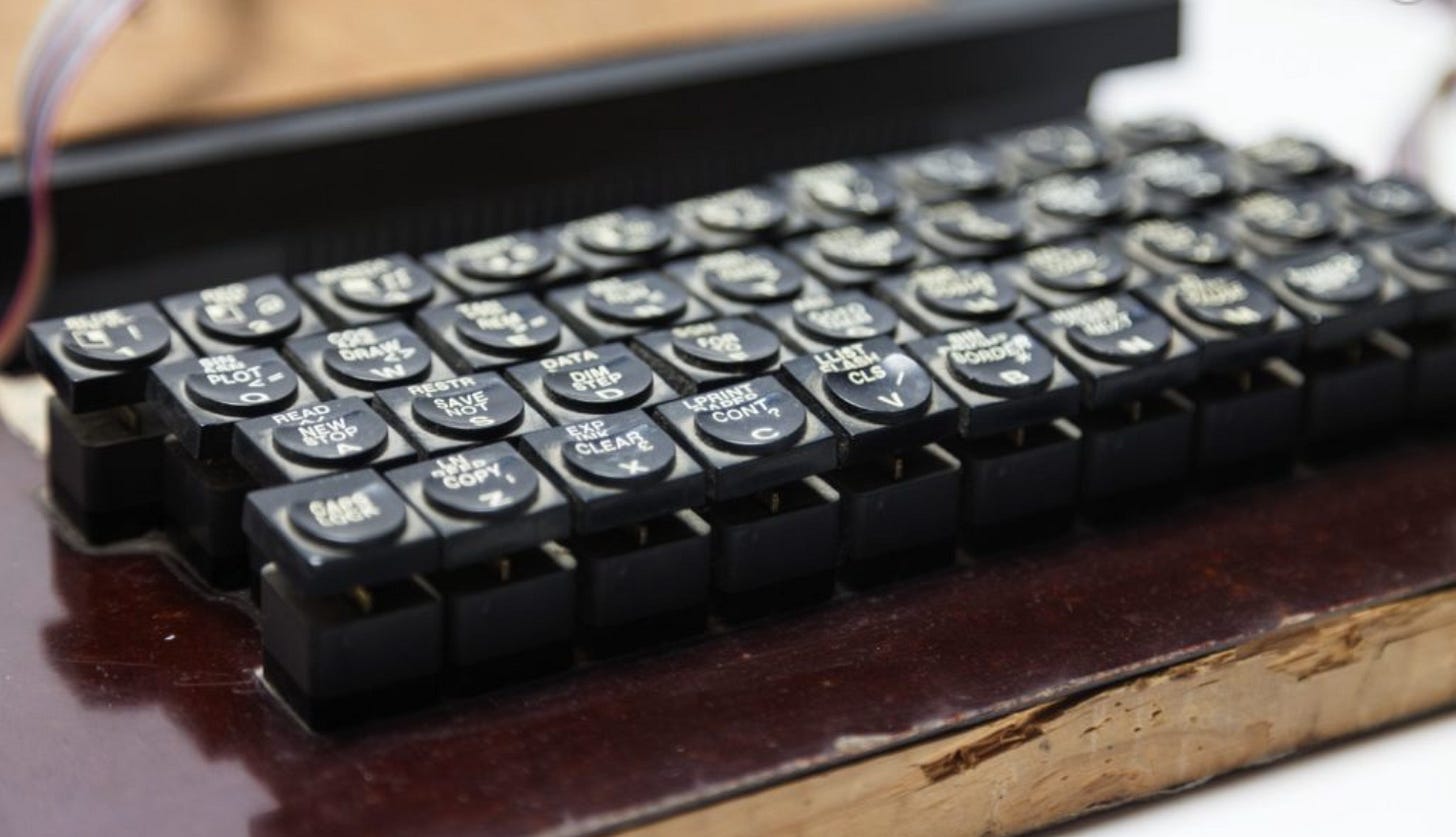Keys from a Spectrum hand-soldered onto a varnished wooden board to make a replacement keyboard. Keys from a Spectrum hand-soldered onto a varnished wooden board to make a replacement keyboard.