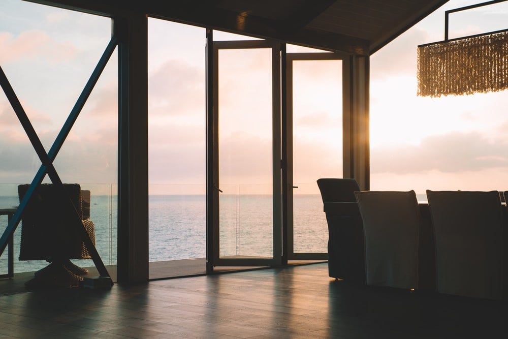white wooden framed glass window beside blue sea