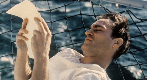 Freddie Quell played by Joaquin Phoenix reads a letter on a ship.