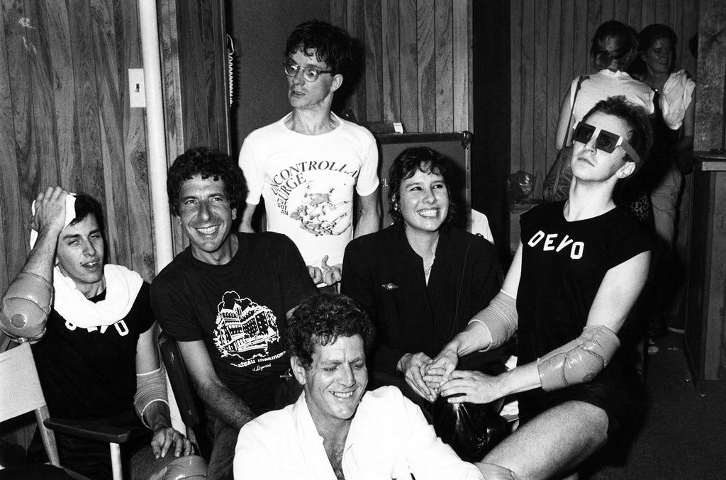 Leonard Cohen, David Blue, Mark Mothersbaugh of Devo, Martine Getty and a Devo member backstage at The Starwood in Los Angeles in 1970.