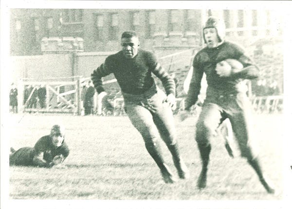 Duke Slater runs on the field during a football game.