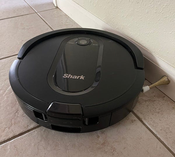 A Shark robot vacuum frozen in place with the power off.